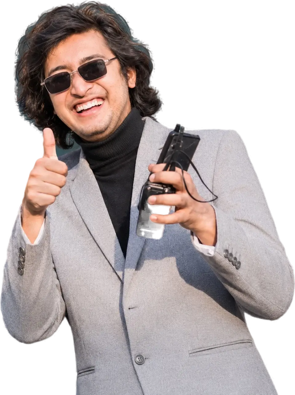 Rajshu Shamsher Rana in sunglasses, a grey blazer and black turtleneck, giving a thumbs up and holding a walkie-talkie